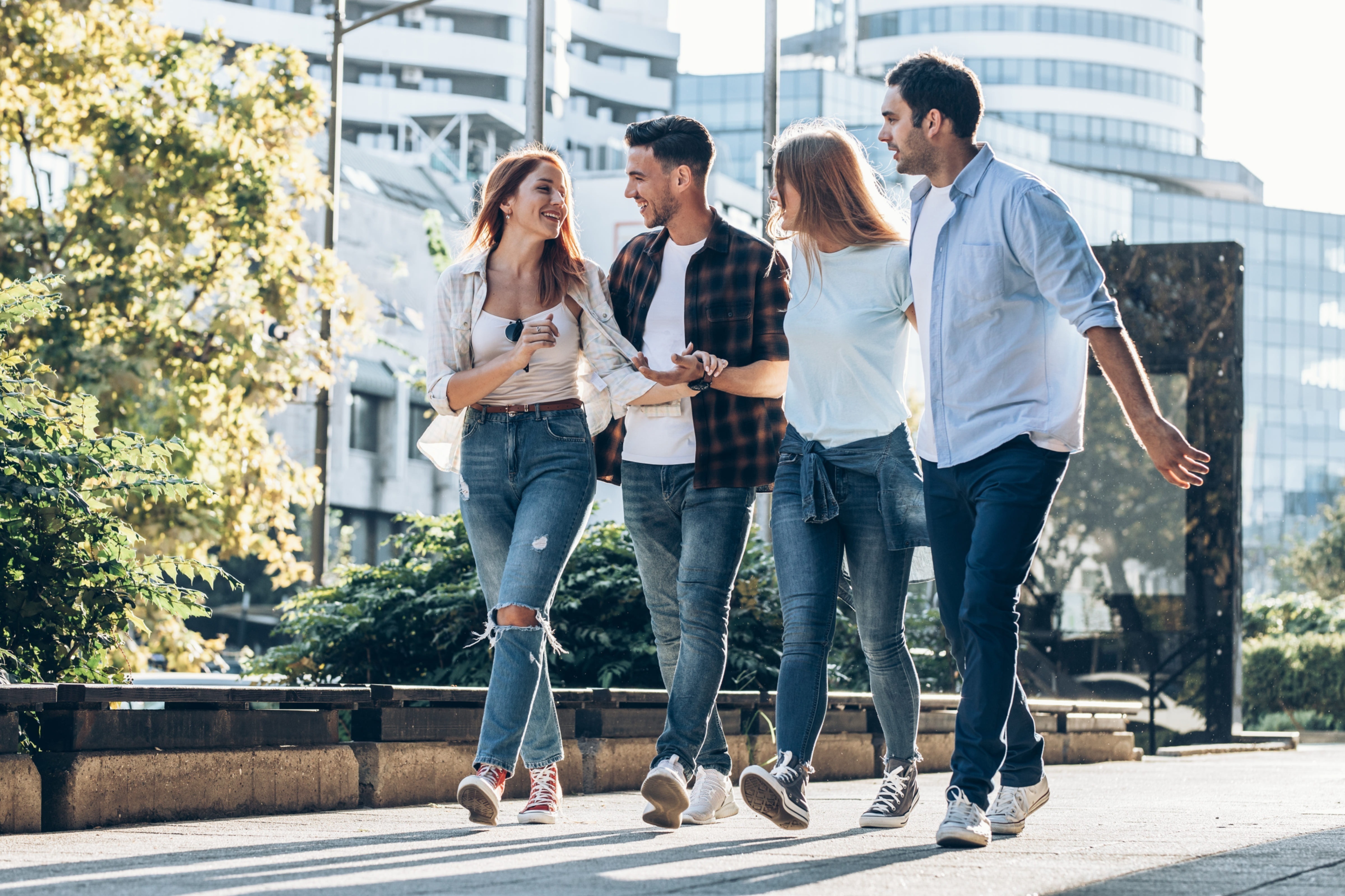 Un groupe de 4 personnes qui discutent et marchent