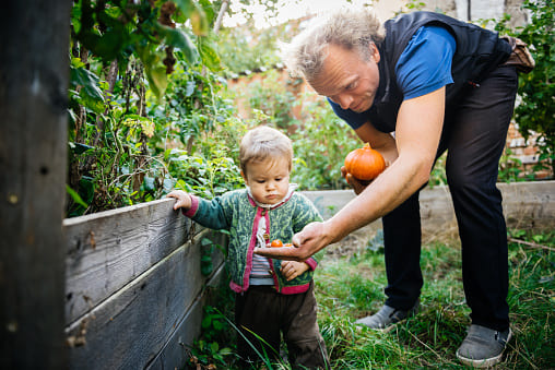 Un enfant et son grand père en train de jardiner
