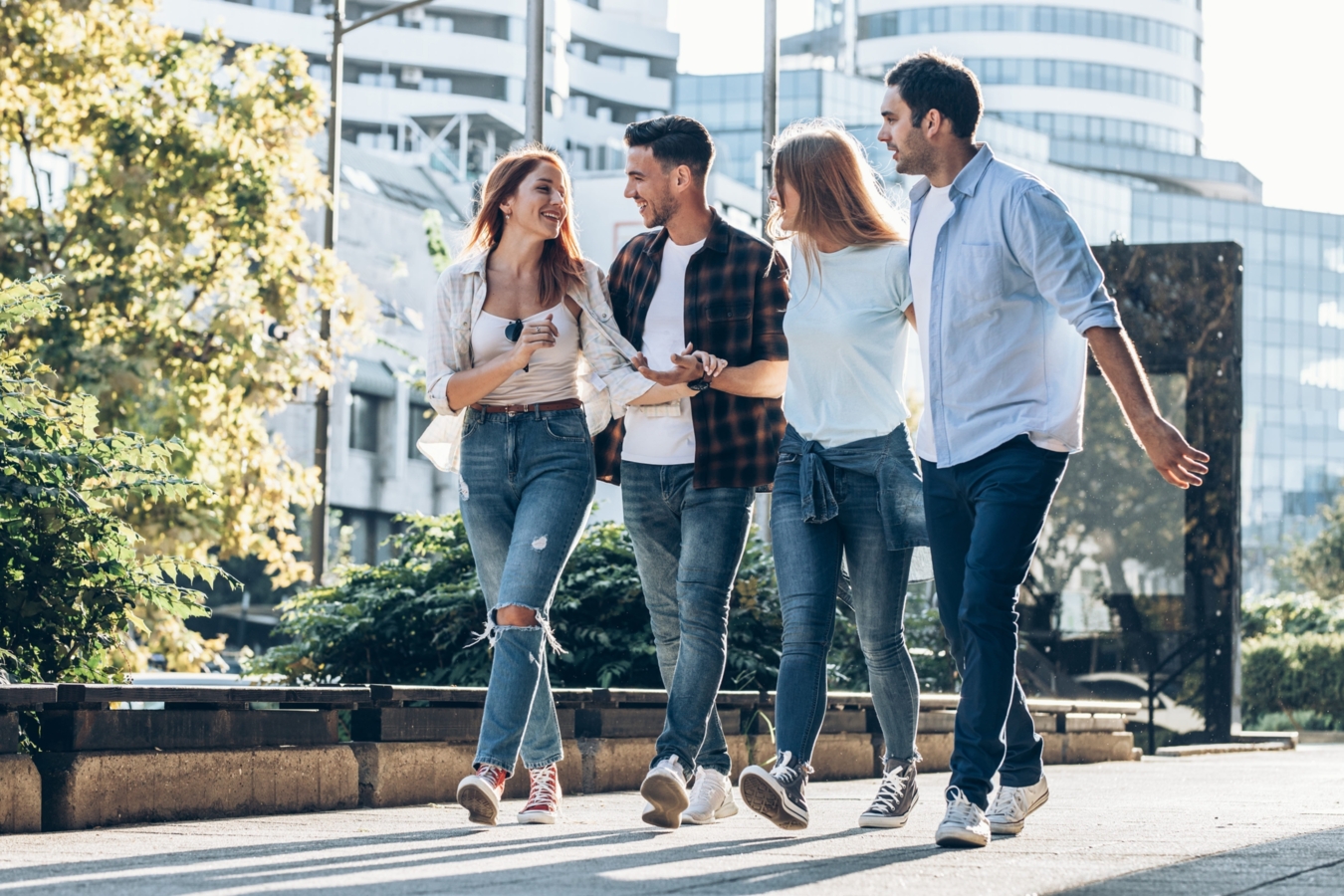 Un groupe de 4 personnes qui discutent et marchent