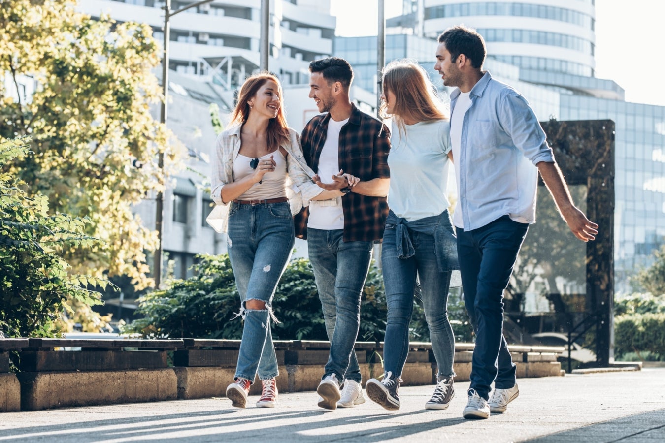 Un groupe de 4 personnes qui discutent et marchent