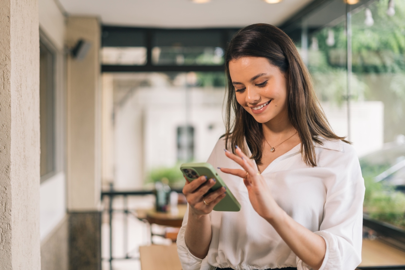Une femme qui souris devant son téléphone